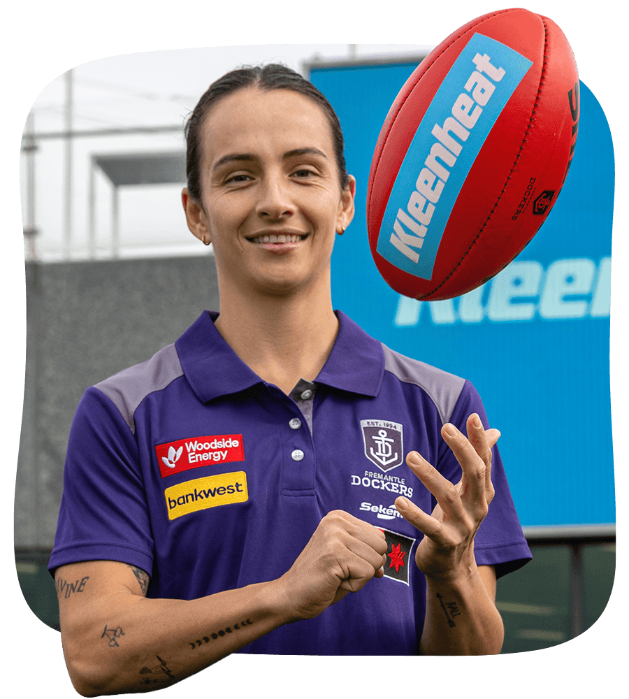 Fremantle Dockers AFLW Team Captain, Ange Stannett, holding a Kleenheat branded football